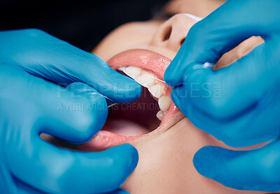 Buy stock photo Shot of a woman having her teeth flossed at the dentists office
