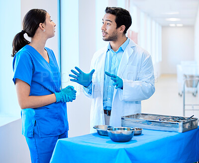 Buy stock photo Shot of a dentist speaking about equipment with his assistant