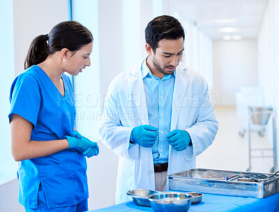 Buy stock photo Shot of a dentist speaking about equipment with his assistant