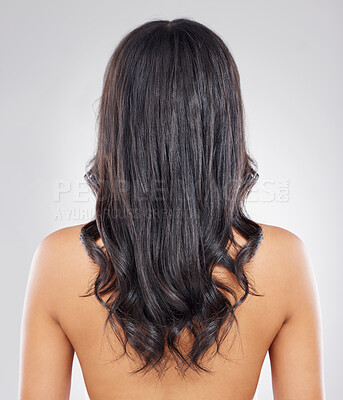 Buy stock photo Rearview shot of an unrecognizable young woman with healthy brown hair posing against a grey background