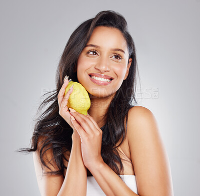 Buy stock photo Cropped shot of an attractive young woman posing with a lemon against a grey background