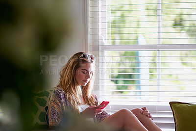 Buy stock photo Relax, typing and woman in home with phone, checking email, online chat or social media post. Communication, connectivity and girl on couch reading message, blog or weekend schedule on smartphone