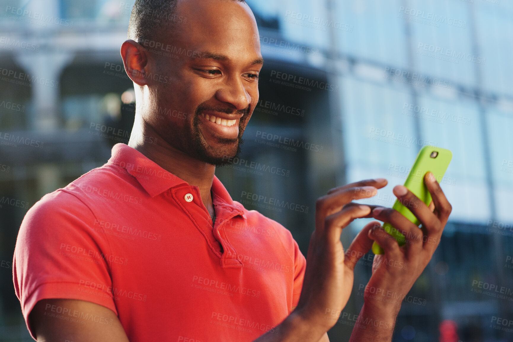 Buy stock photo Shot of a young businessman using a smartphone against an urban background