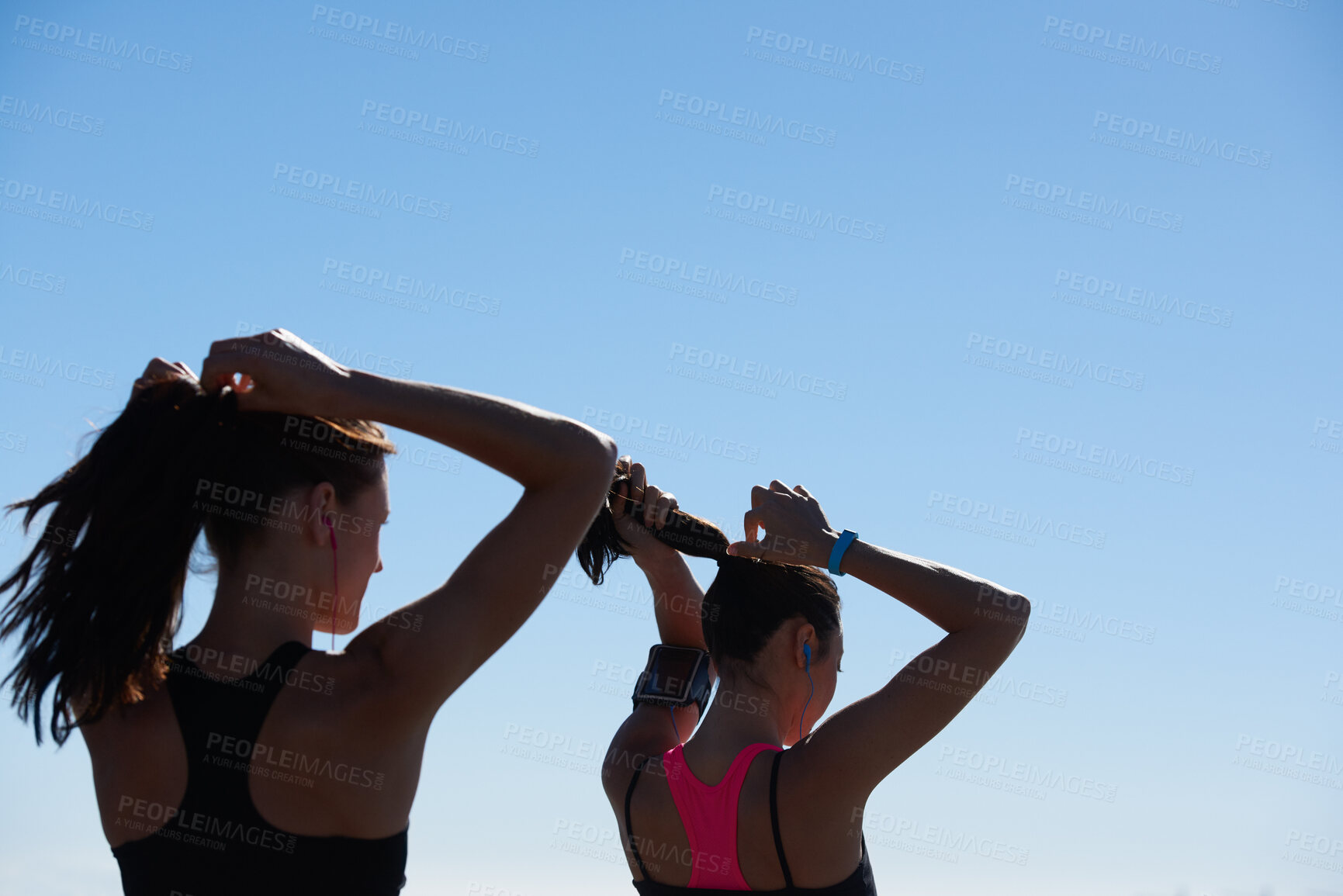 Buy stock photo Fitness women, silhouette and blue sky background of runner tying hair together after outdoor run, cardio exercise and wellness health. Healthy running girls, sports athlete and friends morning run 
