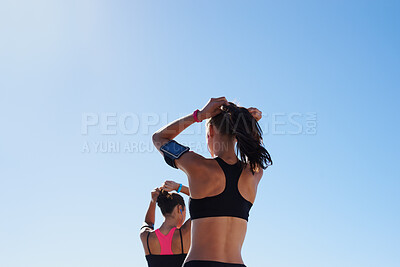 Buy stock photo Fitness women, blue sky background and hair tie for cardio exercise, running workout and summer wellness. Healthy female runners, sports athlete and friends prepare for morning training on sky mockup