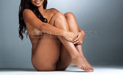 Buy stock photo Studio portrait of a sexy young woman smiling while posing nude against a grey background