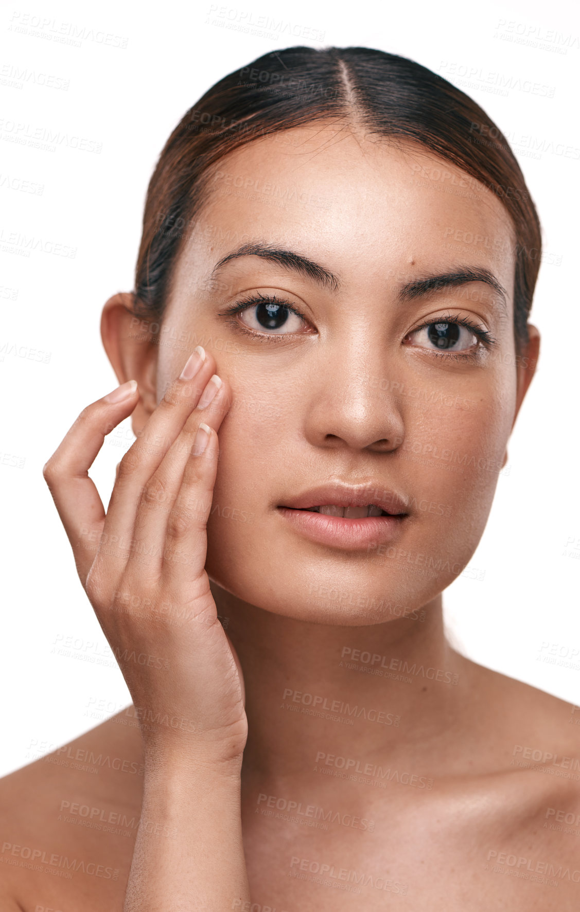 Buy stock photo Shot of a beautiful young woman touching her face while standing against a white background