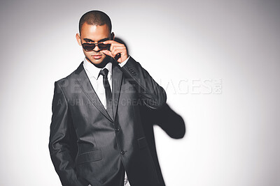 Buy stock photo Man, suit and sunglasses in studio portrait with confidence, fashion and mockup space on white background. Person, bodyguard or government agent with style for secret international mission in London