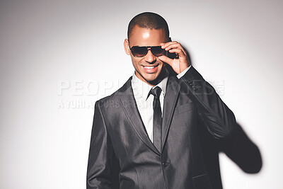 Buy stock photo Man, suit and sunglasses in studio with smile for confidence, fashion and job as spy by white background. Person, bodyguard or government agent with style for secret international mission in London