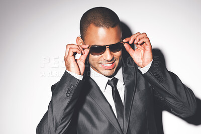 Buy stock photo Fashion, model from Brazil and sunglasses in a studio in a luxury business suit looking cool. Attractive man on set with a white background and happy smile modeling for a rich designer glasses brand