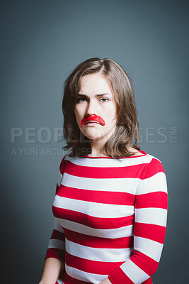 Buy stock photo Studio, portrait and sad woman with moustache for character, facade and cosplay with pride for halloween. Female person, creativity and ready by gray background for persona, red costume and serious