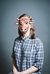 Young woman wearing mask against a grey background in studio