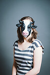 Young woman wearing mask against a grey background in studio