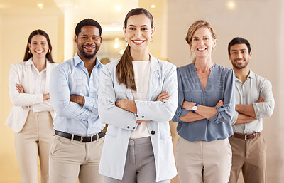 Buy stock photo Portrait of a young businesswoman standing with her arms crossed in an office with her colleagues in the background