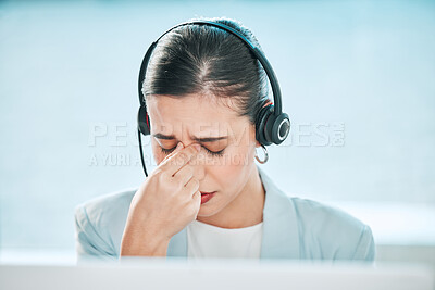 Buy stock photo Shot of a young call centre agent looking stressed out while working on a computer in an office