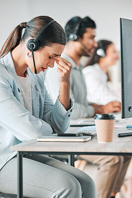 Buy stock photo Shot of a young call centre agent looking stressed out while in an office with her colleagues in the background