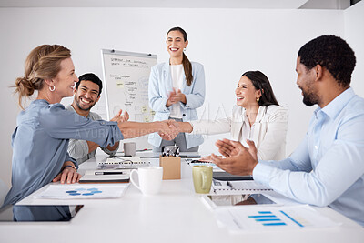 Buy stock photo Cropped shot of two attractive businesswomen shaking hands during a meeting in the boardroom