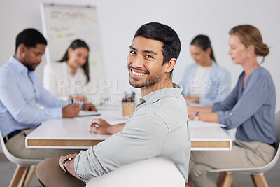 Buy stock photo Cropped portrait of a handsome young businessman sitting in the boardroom during a meeting with her colleagues