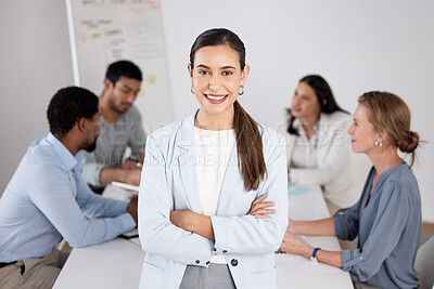 Buy stock photo Cropped portrait of an attractive young businesswoman standing with her arms folded in the boardroom and her colleagues in the background