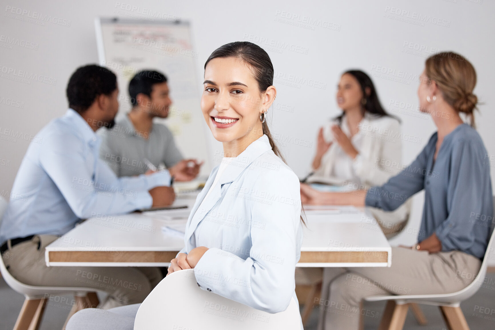 Buy stock photo Cropped portrait of an attractive young businesswoman sitting in the boardroom during a meeting with her colleagues