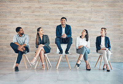 Buy stock photo Full length shot of a handsome young businessman sitting with his colleagues while being the chosen candidate