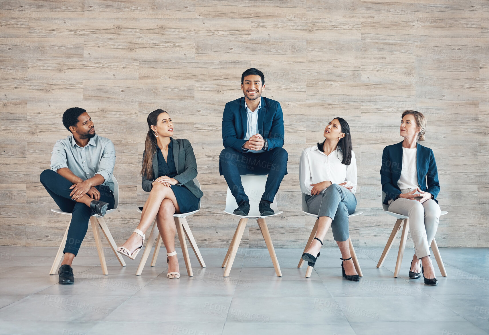 Buy stock photo Full length shot of a handsome young businessman sitting with his colleagues while being the chosen candidate