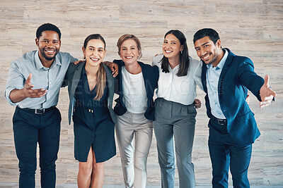 Buy stock photo Shot of a diverse group of businesspeople standing with their arms around in each other in the office