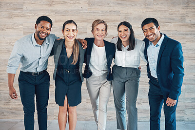 Buy stock photo Shot of a diverse group of businesspeople standing with their arms around in each other in the office