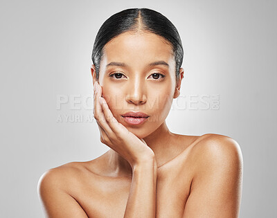 Buy stock photo Studio portrait of an attractive young woman posing against a grey background