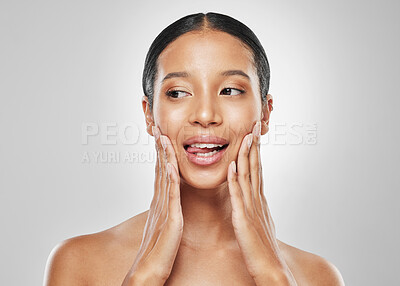 Buy stock photo Studio shot of an attractive young woman sticking out her tongue against a grey background