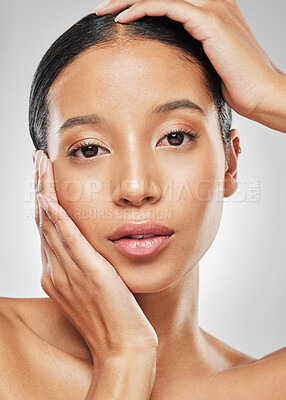 Buy stock photo Studio portrait of an attractive young woman posing against a grey background