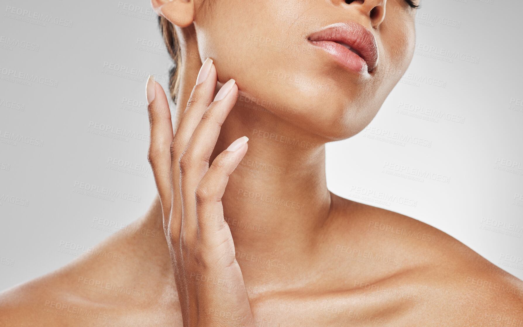 Buy stock photo Studio shot of an unrecognisable woman touching her face against a grey background