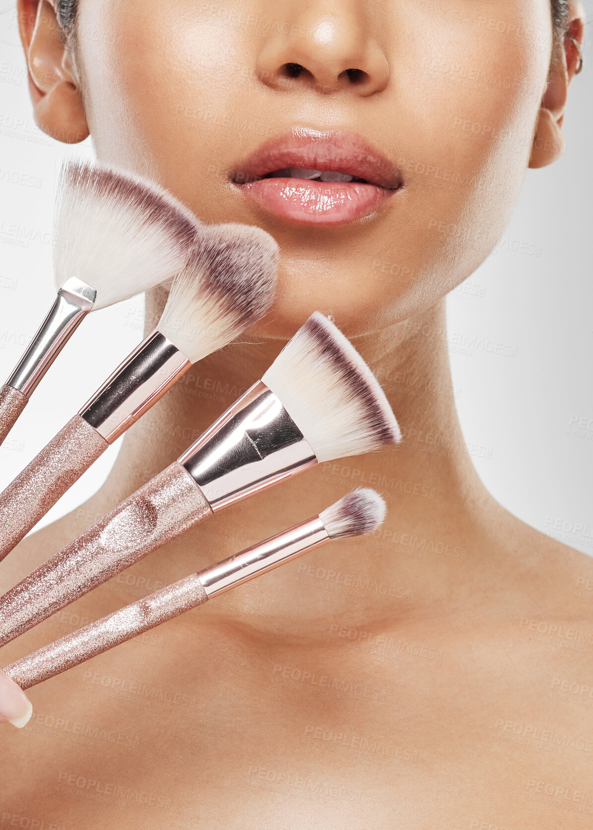 Buy stock photo Studio shot of a unrecognisable woman holding a collection of makeup brushes against a grey background