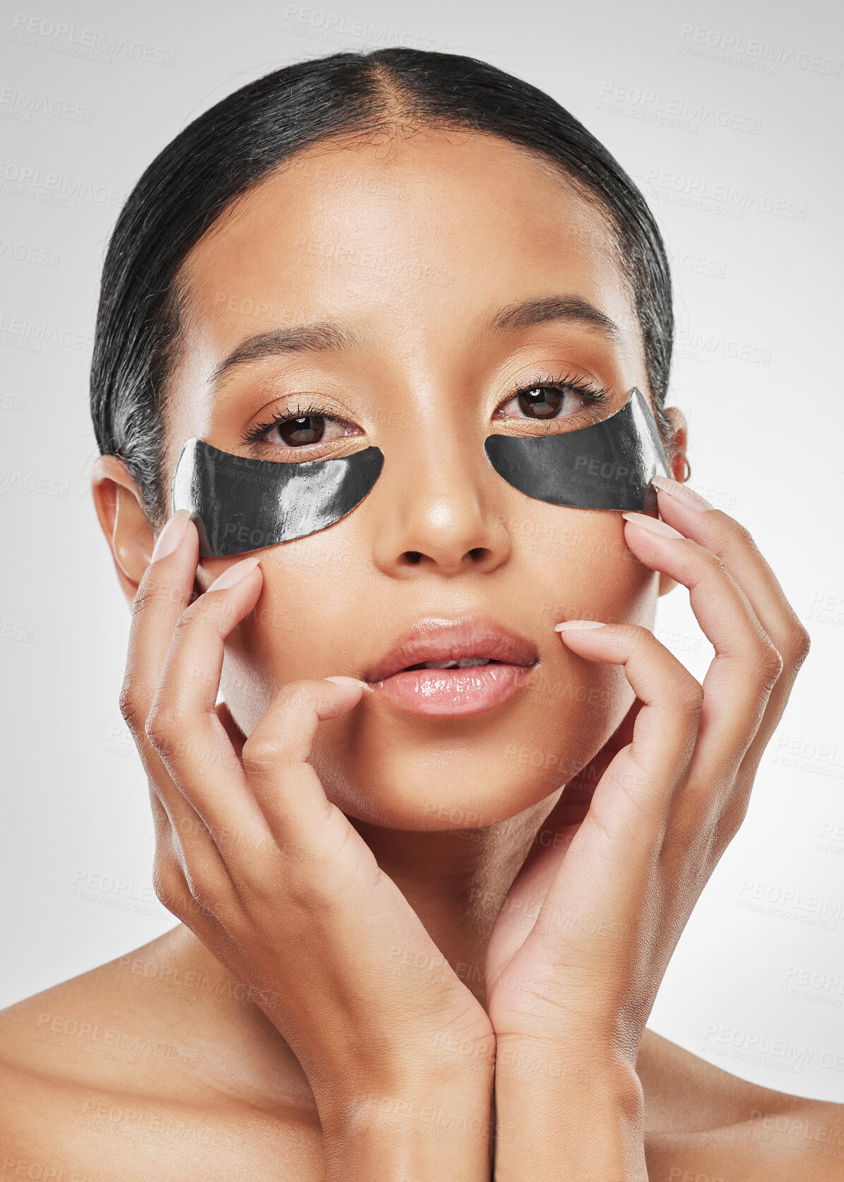 Buy stock photo Studio portrait of an attractive young woman wearing under eye patches against a grey background