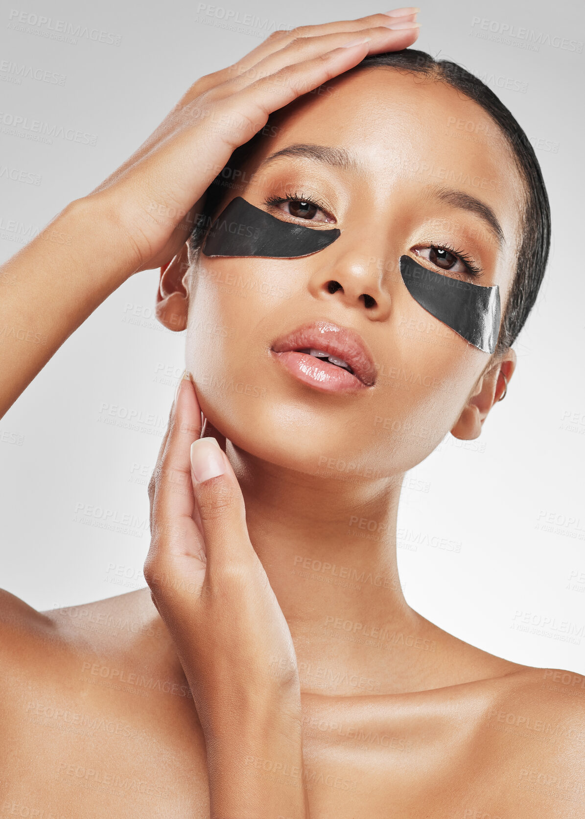 Buy stock photo Studio portrait of an attractive young woman wearing under eye patches against a grey background