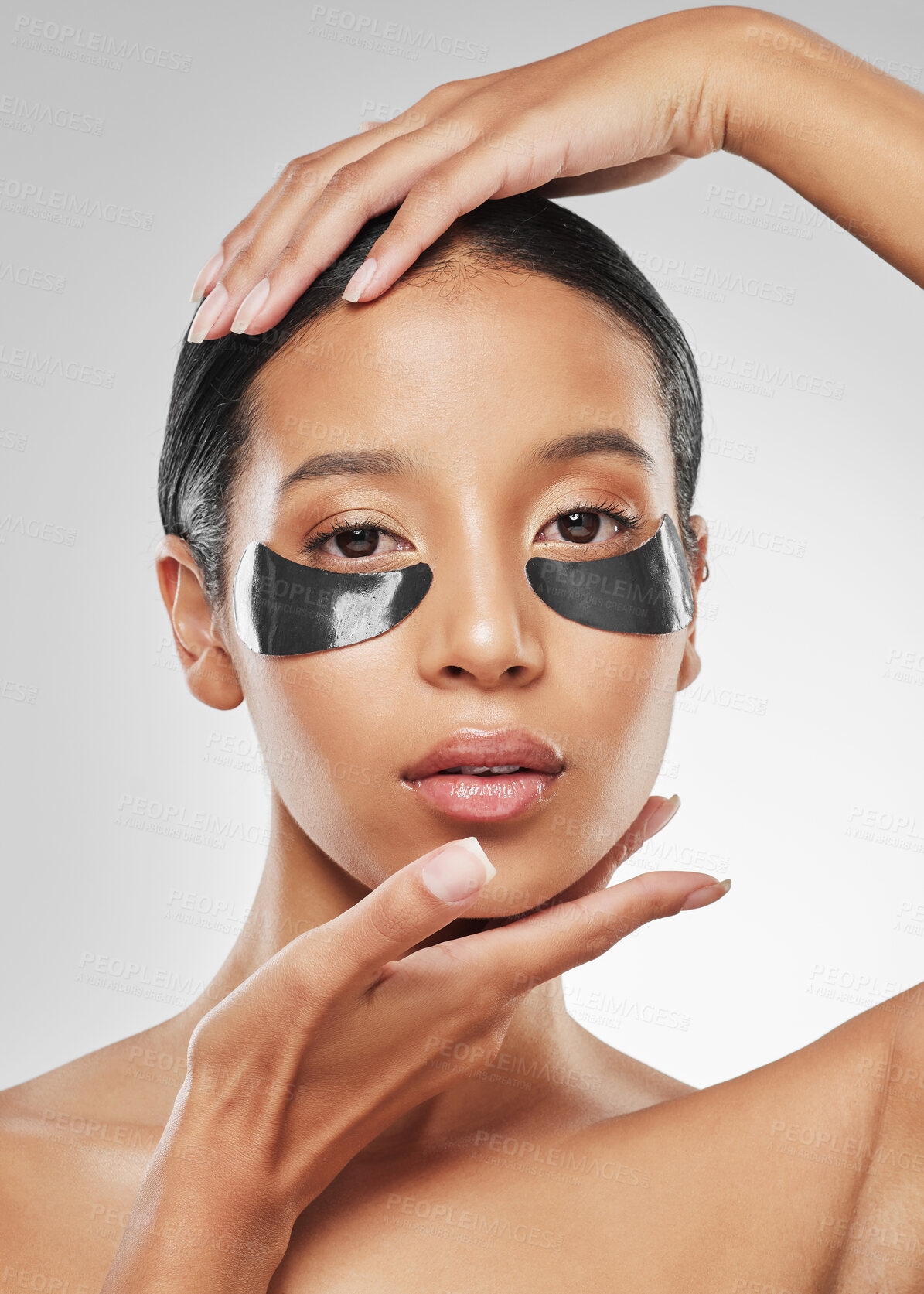 Buy stock photo Studio portrait of an attractive young woman wearing under eye patches against a grey background