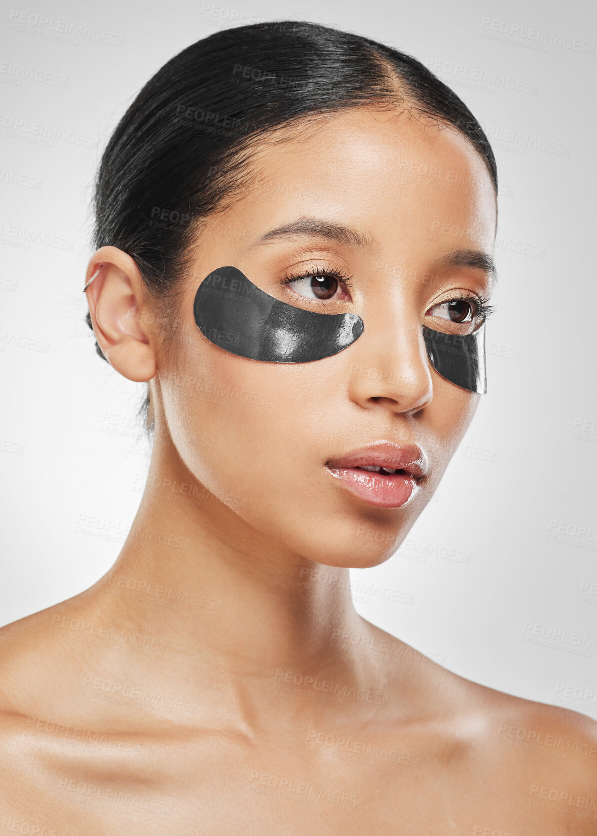 Buy stock photo Studio shot of an attractive young woman wearing under eye patches against a grey background