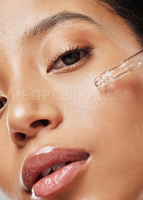 Buy stock photo Portrait of an attractive young woman applying serum to her face