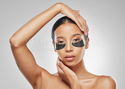 Buy stock photo Studio portrait of an attractive young woman wearing under eye patches against a grey background