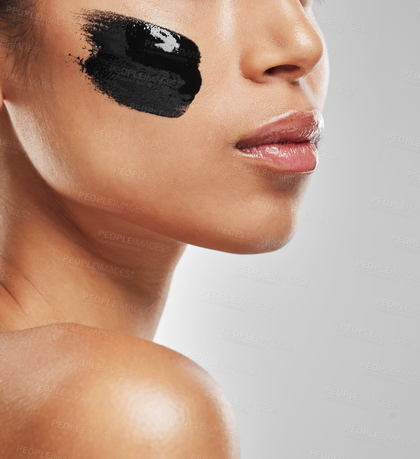 Buy stock photo Studio shot of an unrecognisable woman wearing some charcoal face mask against a grey background