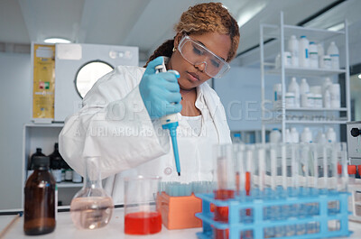Buy stock photo Shot of a young female lab worker filling test tubes with liquid