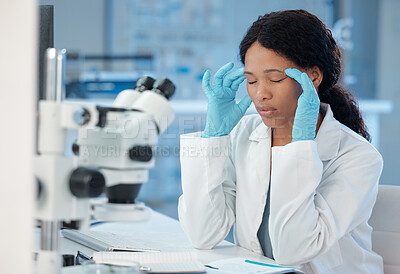 Buy stock photo Shot of a young lab worker experiencing a headache while at work
