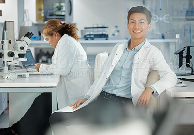 Buy stock photo Shot of a young male lab tech in his office with his coworker