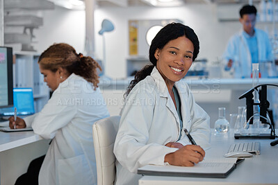 Buy stock photo Shot of a young woman making notes while working in a lab