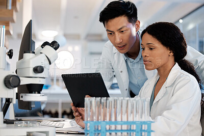 Buy stock photo Shot of two lab techs working together while using a digital tablet