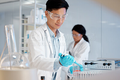 Buy stock photo Shot of a young male lab tech filling up test tube samples