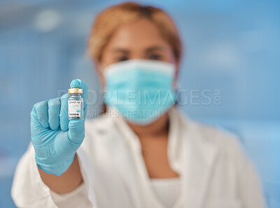 Buy stock photo Shot of a young female lab worker holding a vial of vaccine