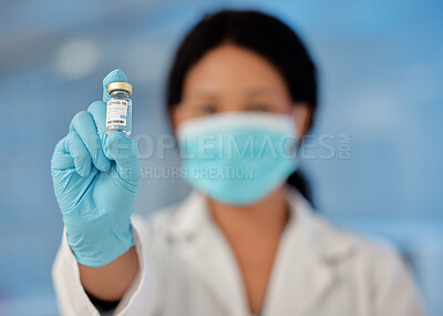 Buy stock photo Shot of a young female lab worker holding a vial of vaccine