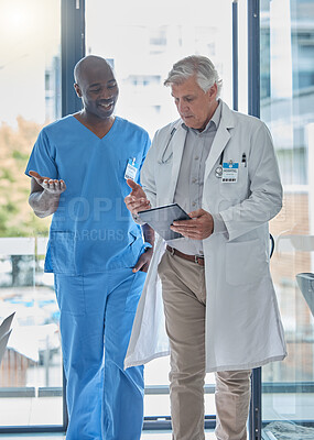 Buy stock photo Cropped shot of two medical professionals talking as they leave the hospital boardroom after a meeting
