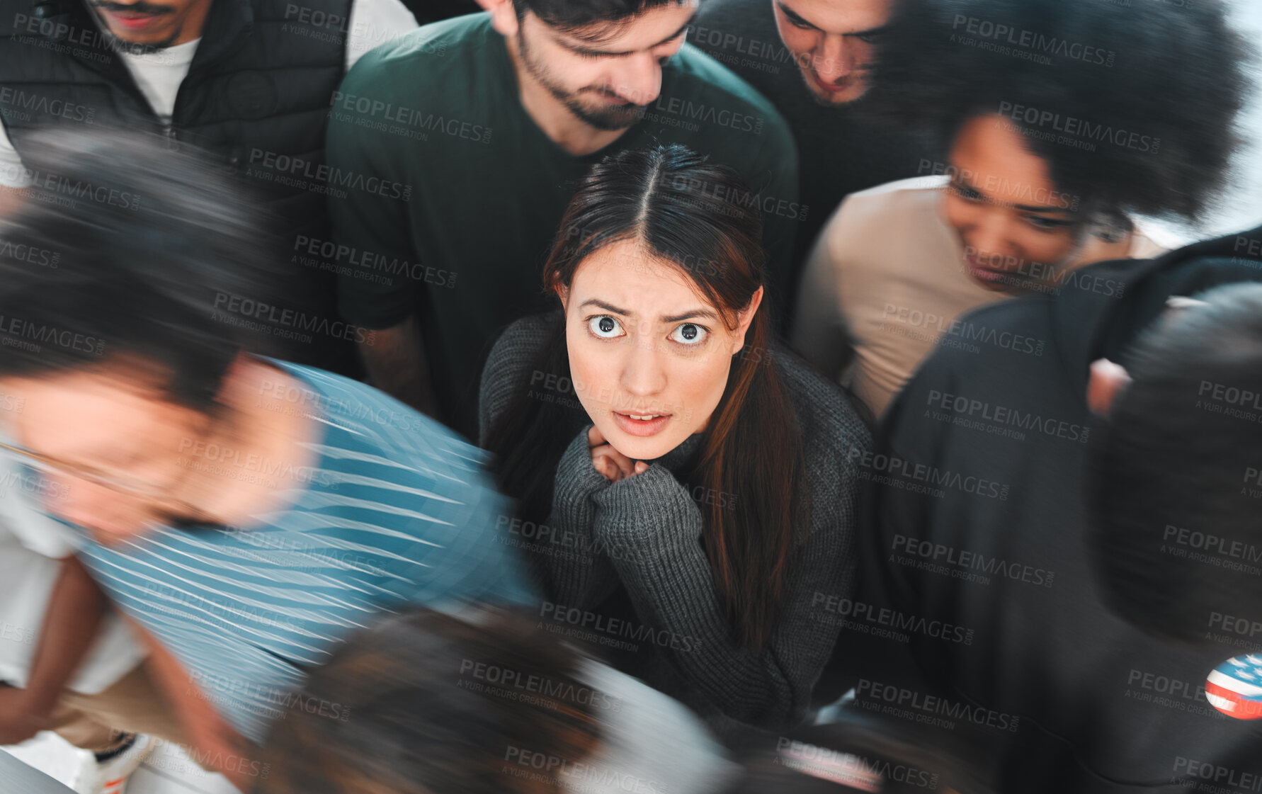 Buy stock photo Shot of a young woman experiencing mental illness while being surrounded by people inside